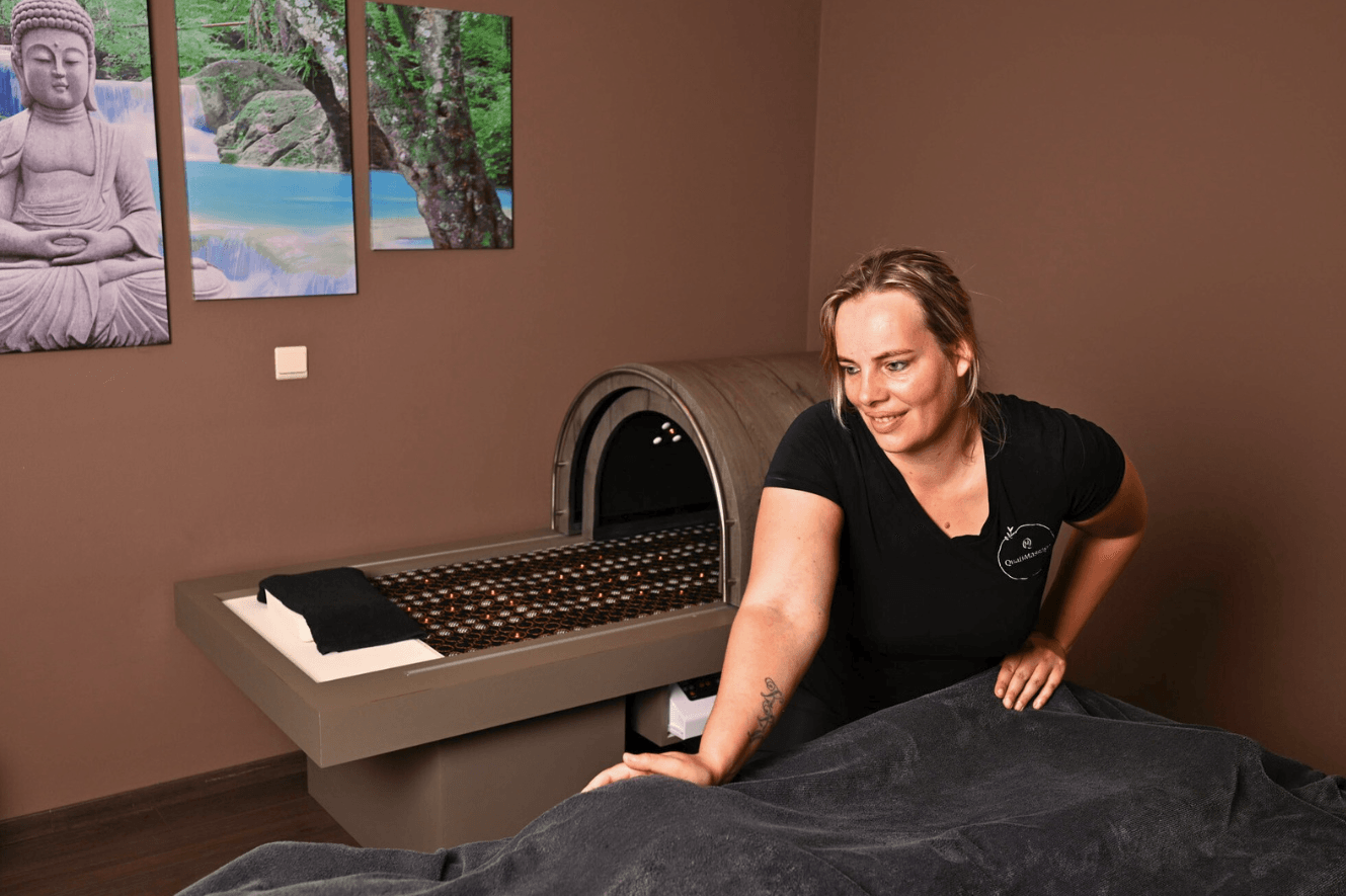 Massage in praktijkruimte van QualiMassage met een infrarood warmtecabine en ontspannende sfeer.