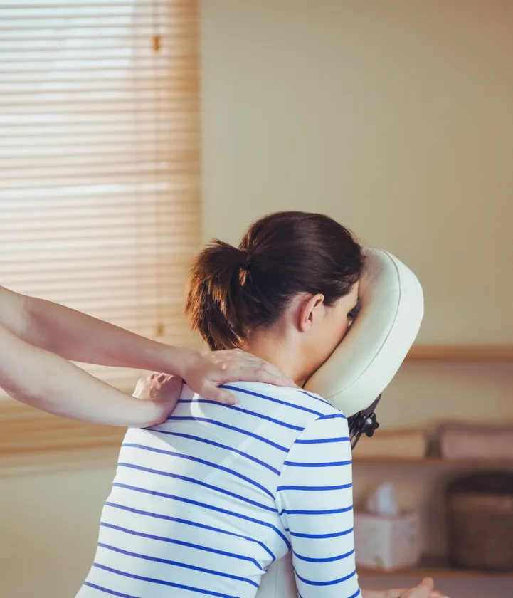 Persoon ontvangt een rugmassage in een massagestoel.